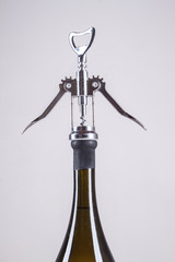 bottle of white wine and a corkscrew for wine