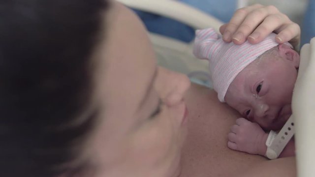 Newborn Baby Girl Laying on Mothers Chest After Delivery in Hospital