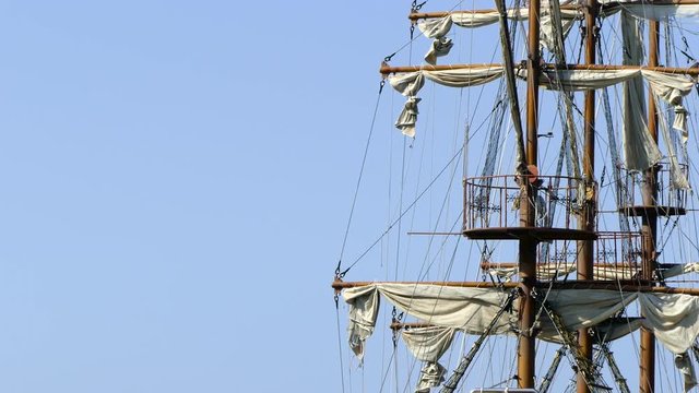 Detailed pirate mast and sails rocking in the wind on a bright day