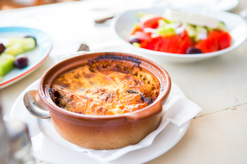 Traditional lunch with musaka and delicious fresh greek salad served for lunch at outdoor...