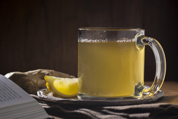 Cup of Hot Lemon Ginger Tea with Lemon Slices and Ginger Root