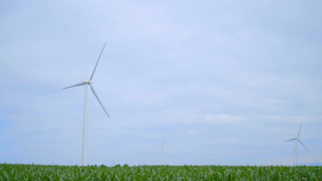 Wind power plant. Wind generators on field. Dolly shot of wind turbines on farm field. Wind turbines landscape. Alternative energy concept. Wind power generation. Wind power resource