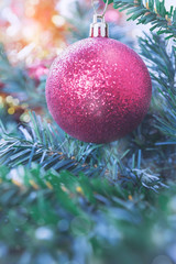 Closeup of Christmas ball with pine branch and gifts on abstract background