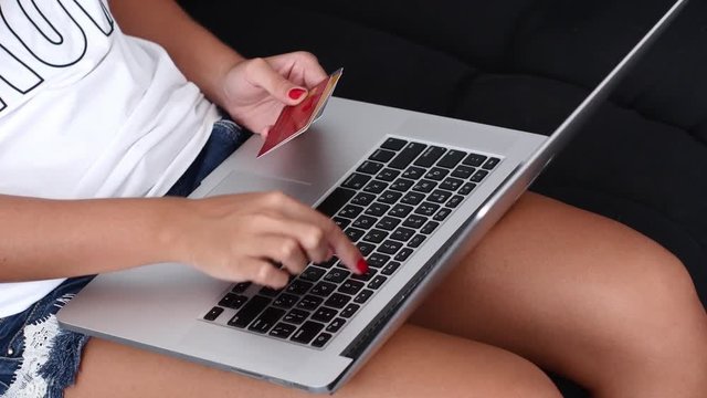 Girl makes a purchase online with help the three credit cards. Close up