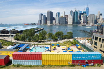 The regenerated Brooklyn Bridge Park featuring a pop-up summer pool with a view of Lower Manhattan in New York City