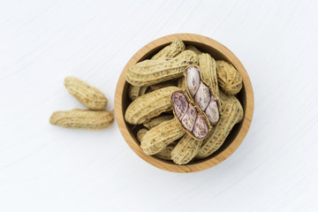 Steamed peanut on round wooden bowl on white background