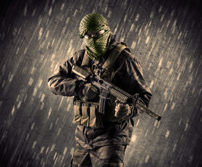 Armed terrorist man with mask on rainy background