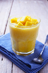 Close up of a healthy glass of mango yogurt smoothie on a wooden