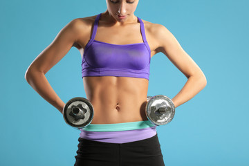 Young woman lifting the dumbbells