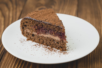 Slice of chocolate cake wiht cream and jam