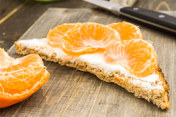mandarin orange segments on brown bread spread with cheese