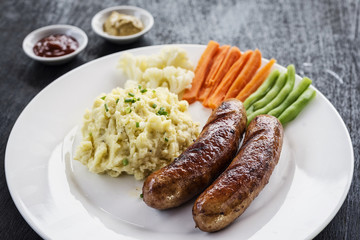 german sausage with mashed potato and vegetables meal