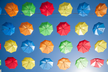 Fototapeta na wymiar blue sky full of color umbrellas in row