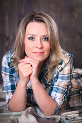 Portrait of a young attractive woman lying on plaid blanket, close-up