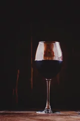 Fotobehang Chilled dry red wine in the glass. Dark vintage wood background. © 5ph