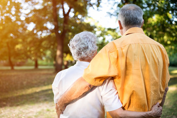 Lovely happy senior couple hugging in park