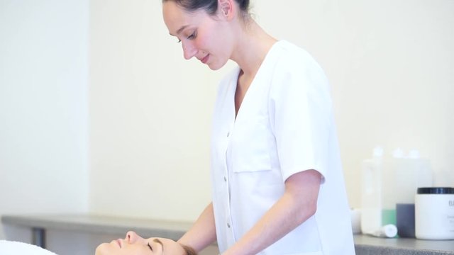 View of a Young attractive masseuse doing a capillariy massage