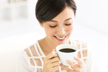 young smiling woman drinking coffee in the morning