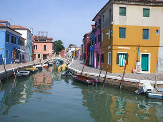 Fototapeta na wymiar Canal in Burano, Italy. Burano is situated 7 kilometres (4 miles) from Venice. Burano is also known for its small, brightly painted houses, which are popular with artists