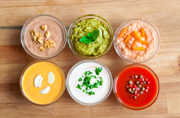 Various sauces in glass bowls on wooden table