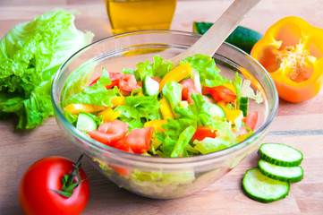 Vegetable salad in a glass bowl on wooden table