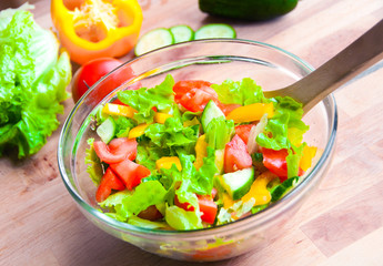 Vegetable salad in a glass bowl on wooden table