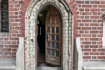 Slightly ajar, medieval and heavy door leading to the interior of the castle
