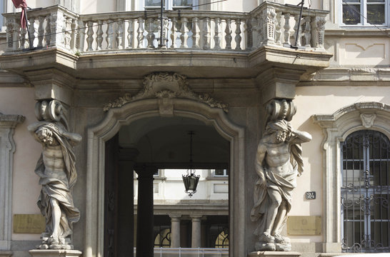 Architectural close up of the entrance of Palazzo Arese Litta in Milan, with two classic statues at its sides