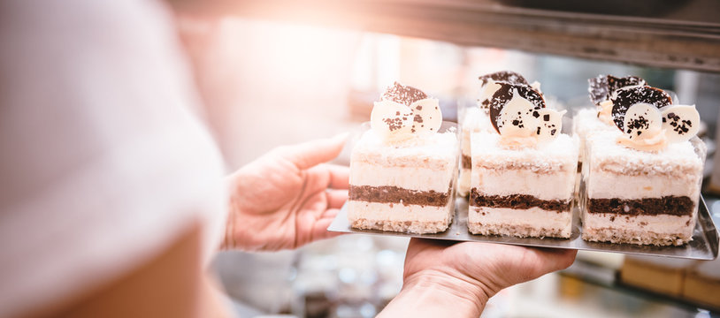 Waitress arranging cakes