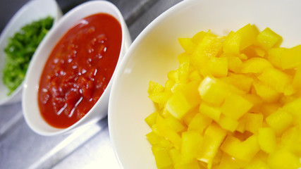 台所のカラフルな野菜　黄色パプリカ　ダイストマト　ピーマン