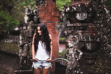Obraz na płótnie Canvas Woman with long black hair surrounded by an old Balinese architec