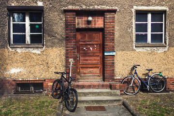 Fototapeta premium Bikes parked near the house with vintage wooden door