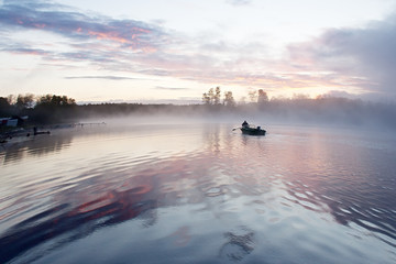 Sunrise at the Seliger lake (Russia) wih mist and boat
