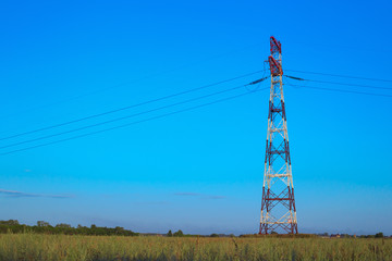 Electrical wiring and power electricity pole on a field at evening time. Electric power....