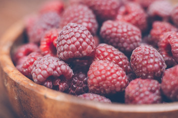 Macro photo of raspberry in wooden bowl, fresh berries close up, summer background