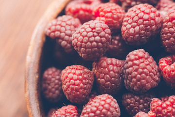Macro photo of raspberry in wooden bowl, fresh berries close up, summer background