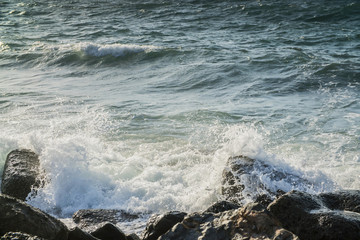 surf the waves off the rocky coast, large bursts of wave