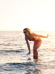 Young woman stepping on something in the shallow water