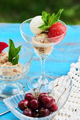 A mix of strawberry, vanilla and caramel ice cream served in a glass beaker on a wooden table