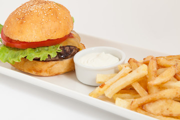 Fresh burger and fries with sauce on white plate