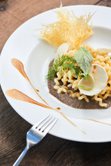 Dinner pasta fusilli with mushroom sauce served on a white plate