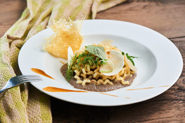 Dinner pasta fusilli with mushroom sauce served on a white plate