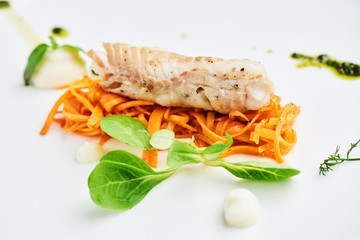 Dinner of Pollock in the marinade, served on a white plate