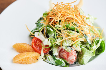 Salad of pike caviar and vegetables served on white plate