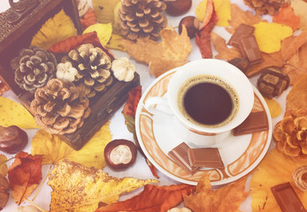 Cup of black coffee, chestnuts, pine cones and autumn leaves. Autumn background. Autumn scene. Coffee and autumn leaves. Fall background