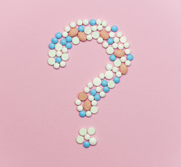 Question mark made of blue, white and orange medication pils