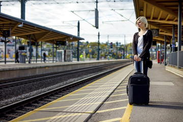 Woman With Luggage Waiting On Platform Of Railroad Station