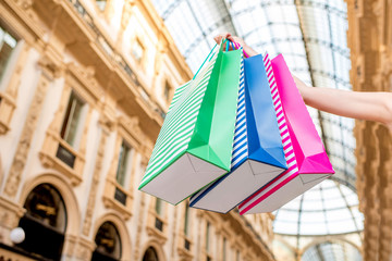 Fototapeta na wymiar Holding colorful shopping bags in the old famous gallery in Milan