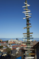 Naklejka premium Signpost to locations around the world in Punta Arenas in southern Chile overlooking the Strait of Magellan.