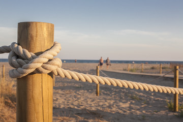Stakes with rope on the beach at sunset